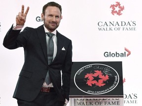 Singer Corey Hart stands beside his star as he is inducted into Canada's Walk of Fame in Toronto on Thursday, October 6, 2016. Hart is being inducted into the Juno Hall of Fame.