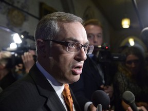 Treasury Board President Tony Clement fields questions in the foyer outside the House of Commons in Ottawa on May 11, 2015.