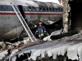 This photo provided by Mizan News Agency, shows an Iranian rescue works at the site of a Boeing 707 cargo plane crash, at Fath Airport about 40 kilometers (25 miles) west of Tehran, Iran, Monday, Jan. 14, 2019.