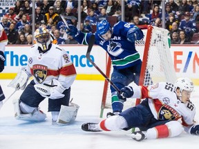 Vancouver Canucks' Tyler Motte crashes into the net behind Florida Panthers goalie Roberto Luongo after having the puck taken away by Bogdan Kiselevich.