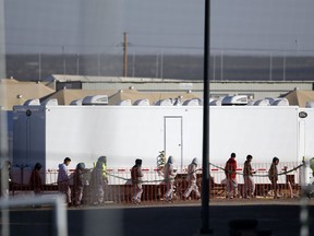 In this Dec. 13, 2018 file photo, migrant teens walk in a line through the Tornillo detention camp in Tornillo, Texas.
