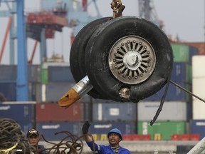 In this Saturday, Nov. 3, 2018, file photo, a crane moves a pair of wheels recovered from the Lion Air jet that crashed into the Java Sea for further investigation at Tanjung Priok Port in Jakarta, Indonesia.