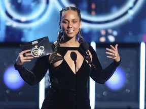 In this Jan. 28, 2018 file photo, Alicia Keys presents the award for record of the year at the 60th annual Grammy Awards at Madison Square Garden in New York.  The Recording Academy announced Tuesday, Jan. 15, 2019,  that Keys will host the Feb. 10 Grammys for the first time.  The show will air live on CBS in Los Angles.
