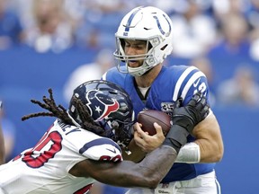 In this Sept. 30, 2018, file photo, Indianapolis Colts quarterback Andrew Luck (12) is sacked by Houston Texans' Jadeveon Clowney (90) during the first half of an NFL football game, in Indianapolis.