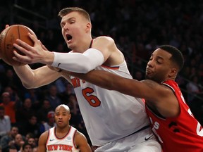 In this Nov. 22, 2017, file photo, Raptors forward Norman Powell (24) tries to strip the ball from Knicks forward Kristaps Porzingis (6) during NBA action in New York.