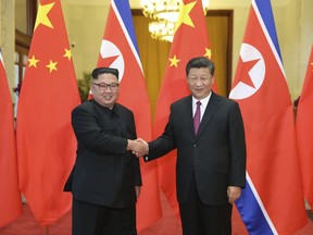 In this June 19, 2018, file photo provided by China's Xinhua News Agency, Chinese President Xi Jinping, right, shakes hands with North Korean leader Kim Jong Un, during a welcome ceremony at the Great Hall of the People in Beijing.