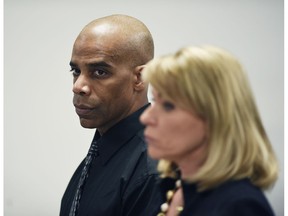 Detroit Police Cpl. Dewayne Jones stands with his attorney Pamella Szydlak as they listen to Judge Cylenthia LaToye Miller during his hearing Tuesday, Jan. 15, 2019 in Detroit. Charges of beating a homeless woman at Detroit Receiving Hospital after she allegedly bit him were dismissed.  The judge has dismissed a felony charge against Jones in the beating of a naked, combative woman who prosecutors say was having a mental breakdown inside an emergency room triage unit. He still faces a misdemeanor assault and battery charge.  (Clarence Tabb Jr./Detroit News via AP)