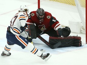 Edmonton Oilers centre Connor McDavid slides the puck between the legs of Arizona Coyotes goaltender Adin Hill for a goal during the second period of an NHL game Wednesday, Jan. 2, 2019, in Glendale, Ariz.