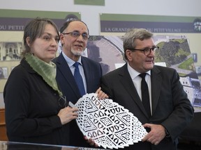 Artist Luce Pelletier, from left, Quebec Islamic cultural centre president Boufeldja Benabdallah and Quebec City mayor Regis Labeaume hold one of the six metal leafs representing one of the six victims of the 2017 Mosque shooting in Quebec City, Tuesday, Jan. 29, 2019.