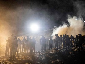 Central American migrants stand amid a cloud of tear gas thrown by the U.S. border patrol, after they tried to cross from Tijuana to San Diego on January 1, 2019. (GUILLERMO ARIAS/AFP/Getty Images)