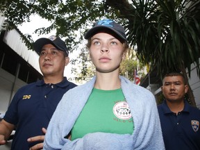 Thai Immigration police officers escort Belarusian model Anastasia Vashukevich, center, from the Immigration Detention Center towards a vehicle to take her to an airport for deportation, in Bangkok, Thailand, Thursday, Jan. 17, 2019.
