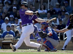 In this March 5, 2018, file photo, Colorado Rockies' D.J. LeMahieu bats during a spring game against the Chicago Cubs, in Scottsdale, Ariz.