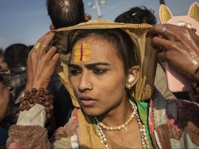 In this Jan. 15, 2019, photo, an Indian hijra walks on the banks after taking a dip along with other members of the newly formed "Kinnar akhara" monastic order on the auspicious Makar Sankranti day during the Kumbh Mela festival in Prayagraj, Uttar Pradesh state, India. (AP Photo/Bernat Armangue)