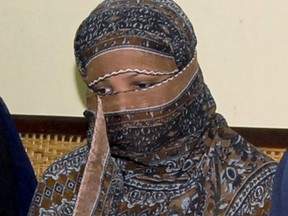 In this Nov. 20, 2010 file photo, Aasia Bibi, a Pakistani Christian woman, listens to officials at a prison in Sheikhupura near Lahore, Pakistan. Pakistan's top court on Tuesday upheld its acquittal of Bibi, who had been sentenced to death for blasphemy.