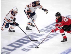 New Jersey Devils Marcus Johansson challenges Edmonton Oilers Matt Benning and Darnell Nurse during the season-opening NHL Global Series game between Edmonton Oilers and New Jersey Devils at Scandinavium in Gothenburg, Sweden, on Oct. 6, 2018.