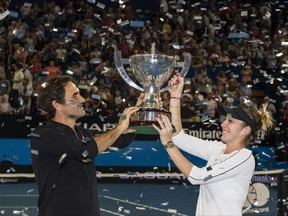 Roger Federer and his mixed doubles partner Belinda Bencic of Switzerland with the Hopman Cup after defeating runners-up Alexander Zverev and Angelique Kerber of Germany in the final on day eight of the Hopman Cup tennis tournament in Perth on Jan. 5, 2019. (TONY ASHBY/AFP/Getty Images)