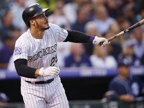 In this Aug. 21, 2018, file photo, Colorado Rockies' Nolan Arenado watches his RBI-double off San Diego Padres pitcher Robbie Erlin during a game in Denver. (AP Photo/David Zalubowski, File)