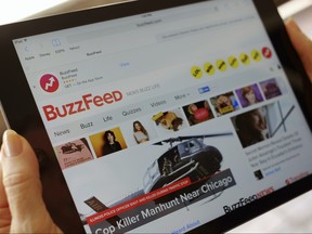 In this Sept. 2, 2015, file photo the BuzzFeed website is displayed on an iPad held by an Associated Press staffer in Los Angeles. (AP Photo/Richard Vogel, File)