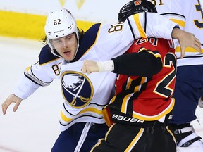 Buffalo Sabres defenceman Nathan Beaulieu tangles with Calgary Flames forward Curtis Lazar at the Scotiabank Saddledome on Calgary on Monday, January 22, 2018. (Gavin Young/Postmedia)