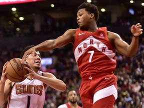 Toronto Raptors guard Kyle Lowry gets a hand to the ball as Phoenix Suns guard Devin Booker (1) drives for the basket during second half NBA basketball action in Toronto on Thursday Jan. 17, 2019.
