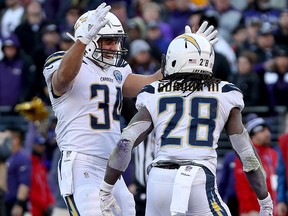 Melvin Gordon of the Los Angeles Chargers celebrates with Derek Watt  after scoring a one-yard touchdown against the Baltimore Ravens during the fourth quarter in the AFC Wild Card Playoff game at M&T Bank Stadium on Jan. 6, 2019 in Baltimore, Md.
