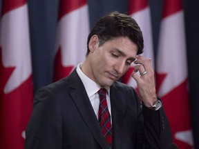 Prime Minister Justin Trudeau scratches his forehead as he listens to a question during an end of session news conference in Ottawa on Dec. 19, 2018.