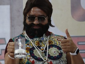 In this May 17, 2017, file photo, Indian spiritual leader turned actor who calls himself Dr. Saint Gurmeet Singh Ram Rahim Insan gestures as he holds up a glass of milk at a "Cow Milk Party" during the premiere of the movie "Jattu Engineer" in New Delhi, India.