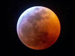 Earth's shadow almost totally obscures the view of the so-called Super Blood Wolf Moon during a total lunar eclipse, on Sunday January 20, 2019, in Miami, Florida. (GASTON DE CARDENAS/AFP/Getty Images)