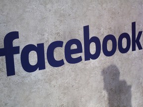This Jan. 17, 2017, file photo shows a Facebook logo displayed in a start-up companies gathering at Paris' Station F in Paris. Facebook says it is investing $300 million over the next three years in local news programs, partnerships and other initiatives. The cash investment includes reporting grants for local newsrooms and investing in nonprofits aimed at helping support local news. (AP Photo/Thibault Camus, File)