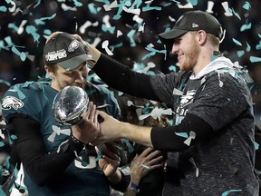 In this Feb. 4, 2018, file photo, Philadelphia Eagles quarterback Carson Wentz, right, hands the Vincent Lombardi trophy to Nick Foles after the Eagles defeated the New England Patriots 41-33 in the NFL Super Bowl 52 football game in Minneapolis. (AP Photo/Frank Franklin II, File)