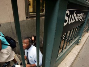 Commuters climb the stairs from a subway station on Wall Street July 7, 2005 in New York City. (Spencer Platt/Getty Images)