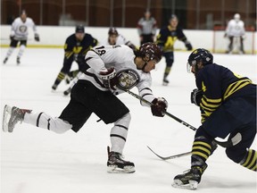 NAIT Ooks' Colton Waltz stops battles MacEwan Griffins' Nakehko Lamothe during the first period of Game 3 of the Alberta Colleges Athletic Conference men's hockey final at Northern Alberta Institute of Technology in Edmonton, on Sunday, March 18, 2018.