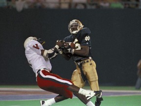 In this Aug. 31, 1989, photo, Notre Dame's Raghib Ismail (25) catches a 52-yard pass covered by Virginia's Jason Wallace in the first quarter of the Kickoff Classic at Giants Stadium in East Rutherford, N.J. (AP Photo/Steven Freeman)