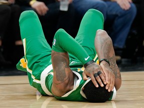 Boston Celtics' Kyrie Irving covers his eyes after an injury during the second half of an NBA basketball game against the San Antonio Spurs, Monday, Dec. 31, 2018, in San Antonio.