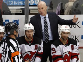 In this Nov. 5, 2018, file photo, New Jersey Devils head coach John Hynes talks with referee Marc Joannette (25) during a game against the Pittsburgh Penguins, in Pittsburgh. (AP Photo/Gene J. Puskar, File)