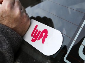 In this Jan. 31, 2018, file photo, a Lyft logo is installed on a driver's car in Pittsburgh. (AP Photo/Gene J. Puskar, File)