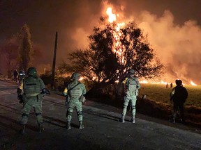 This handout photo distributed by the Mexican Secretary of National Defence shows soldiers standing guard near a fire after a leaking gas pipeline triggered a blaze in Tlahuelilpan, Hidalgo state, on January 18, 2019. (Getty Images)