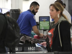 A Transportation Security Administration officer works at a checkpoint at Miami International Airport, Sunday, Jan. 6, 2019, in Miami. (AP Photo/Lynne Sladky)