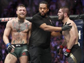 In this Oct. 6, 2018, file photo, Conor McGregor, left, and Khabib Nurmagomedov, right, are separated during a UFC 229 mixed martial arts bout in Las Vegas.