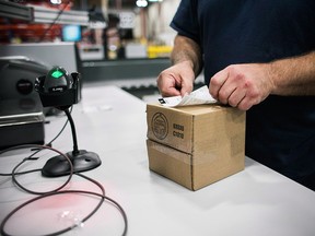A worker applies a shipping label to a package of cannabis products at the Ontario Cannabis Store distribution centre in an undated handout photo.