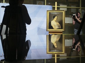 The painting 'Portrait of a Seated Young Woman' by Thomas Couture stands on a easel during a restitution ceremony to the heirs of Jewish French politician Georges Mandel in Berlin, Tuesday, Jan. 8, 2019. (AP Photo/Markus Schreiber)