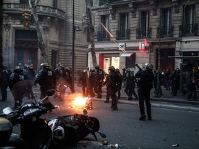 A riot policeman fires a teargas shell during an anti-government demonstration called by the yellow vest "Gilets Jaunes" movement in Paris on Saturday, Jan. 5, 2019.