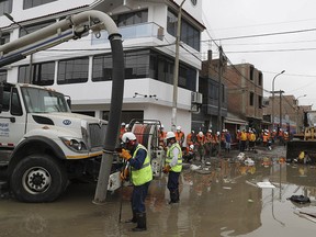 City water workers drain a street filled with sewage in the San Juan de Lurigancho district of Lima, Peru, Wednesday, Jan. 16, 2019. (AP Photo/Martin Mejia)