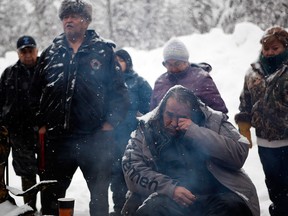 Alexander Joseph, centre right, from the Babine Lake First Nation gets emotional as Chief Madeek, hereditary leader of the Gidimt'en clan, second left, speaks with supporters of the Unist'ot'en camp and Wet'suwet'en people at a checkpoint near Houston, B.C., on Wednesday, Jan. 9, 2019.