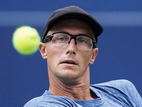 Peter Polansky of Canada returns a shot to Novak Djokovic of Serbia during second round men's Rogers Cup tennis tournament action in Toronto, Wednesday, Aug, 8, 2018.