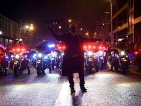 A man stands in front of police motorcycles as protesters face Paterson police officers during a rally, Tuesday, Jan. 8, 2019, in Paterson, N.J. (Danielle Parhizkaran/The Record via AP)