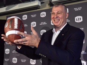 CFL commissioner Randy Ambrosie tosses a football as he speaks during a press conference in Toronto on July 5, 2017.