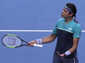 Canada's Milos Raonic gestures as he queries a line call with the chair umpire during his quarterfinal match against France's Lucas Pouille at the Australian Open in Melbourne, Australia, Wednesday, Jan. 23, 2019. (AP Photo/Mark Schiefelbein)