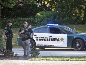 In this Feb. 14, 2018 file photo, law enforcement officers block off a street following a shooting at Marjory Stoneman Douglas High School in Parkland, Fla. (AP Photo/Wilfredo Lee, File)