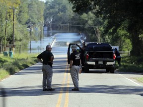 In this Wednesday, Sept. 19, 2018, file photo, responders congregate near where two people drowned when they were trapped in a Horry County Sheriff's transport van while crossing an overtopped bridge over the Little Pee Dee River on Highway 76, during rising floodwaters in the aftermath of Hurricane Florence in Marion County, S.C. (AP Photo/Gerald Herbert, File)